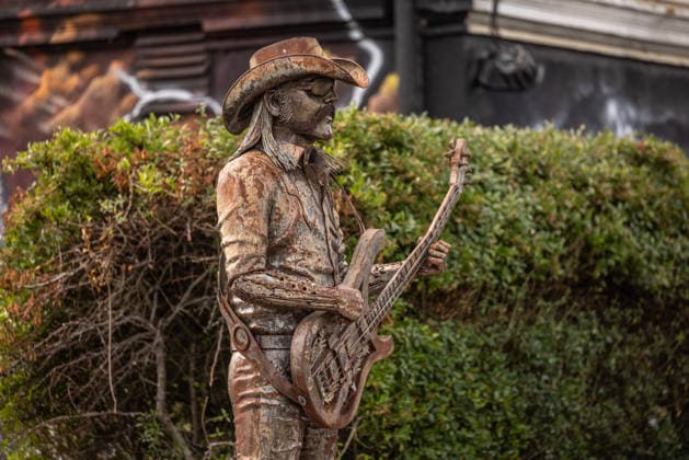 Das Dorf Wacken füllt sich bereits am Montag wieder mit Fans aus aller Welt, Lemmy Kilmisters Statue am Langasthof beobachtet die Szene, Das Wetter hat sich pünktlich zum Montag gebebessert. Zeit für die angereisten Metalheads in das berühmte Dorf Wacken zu gehen, um sich mit Getränken und T-Shirts einzudecken. Wacken Wacken open Air Schleswig Holstein Deutschland _5DL7405 *** The village of Wacken is already filling up again on Monday with fans from all over the world; Lemmy Kilmister’s statue at the Langasthof watches over the scene, The weather has improved just in time for Monday—time for the metalheads who’ve traveled here to head into the famous village of Wacken to stock up on drinks and T-shirts. Wacken, Wacken Open Air, Schle