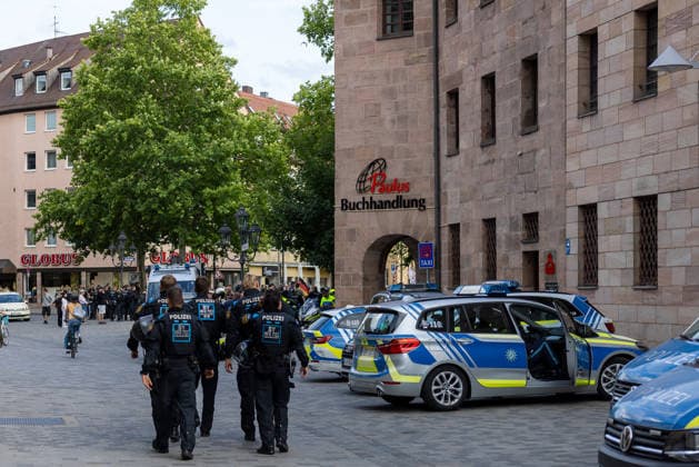 Montagsdemo Team Menschenrechte mit Gegendemonstration und Blockaden, Nürnberg, 27.07.2026 Mehrere Polizeibeamte in Einsatzausrüstung gehen zu Fuß entlang einer Einkaufsstraße, im Hintergrund eine Gruppe von Versammlungsteilnehmern. Zahlreiche Streifenwagen der Polizei stehen mit geöffneten Türen am Straßenrand bereit. Nürnberg Bayern Deutschland *** Monday Demonstration: Human Rights Team with a counter-demonstration and blockades, Nuremberg, July 27, 2026 Several police officers in tactical gear are walking along a shopping street; in the background, a group of demonstrators. Numerous police patrol cars are parked at the roadside with their doors open. Nuremberg, Bavaria, Germany 20260727-286A2940-M4000