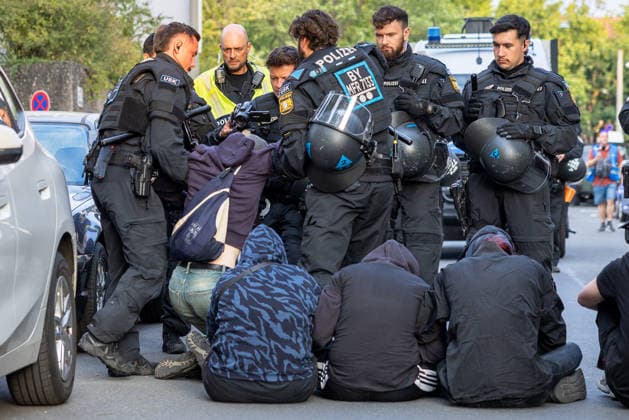 Montagsdemo Team Menschenrechte mit Gegendemonstration und Blockaden, Nürnberg, 27.07.2026 Einsatzkräfte der Polizei in Schutzausrüstung lösen eine Sitzblockade von Demonstranten auf. Mehrere Personen sitzen am Boden und werden von Beamten umringt, während im Hintergrund ein ein Polizifahrzeug bereitsteht. Nürnberg Bayern Deutschland *** Monday Demonstration: Human Rights Team Holds Counter-Demonstration and Sets Up Blockades, Nuremberg, July 27, 2026 Police officers in protective gear disperse a sit-in by demonstrators. Several people are sitting on the ground and are surrounded by officers, while a police vehicle stands by in the background. Nuremberg, Bavaria, Germany 20260727-286A2990-M4000