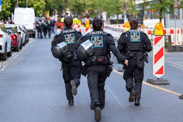 Montagsdemo Team Menschenrechte mit Gegendemonstration und Blockaden, Nürnberg, 27.07.2026 Mehrere Polizeibeamte in Schutzausrüstung mit Helmen laufen im Einsatz über eine Straße. Am Straßenrand sichern Absperrungen und Warnbaken den Bereich. Nürnberg Bayern Deutschland *** Monday Demonstration: Human Rights Team Holds Counter-Demonstration and Sets Up Blockades, Nuremberg, July 27, 2026. Several police officers in protective gear, including helmets, are on duty, walking across a street. At the roadside, barriers and warning cones secure the area. Nuremberg, Bavaria, Germany 20260727-6V2A0416-M4000