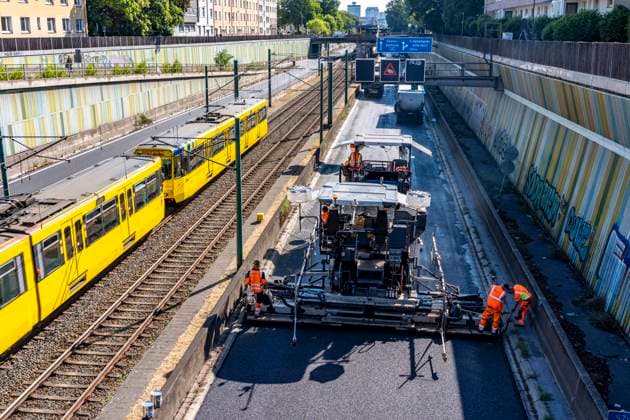 Sanierung der Autobahn A40 zwischen Mülheim-Winkhausen und Essen-Ost, auf 5,8 Kilometer wurde die Asphaltdecke erneuert, mit s.g. Flüsterasphalt, offenporiger Asphalt, in beide Fahrtrichtungen, insgesamt über 110.000 Quadratmeter, eine Woche Vollsperrung, mit starker Verkehrsbehinderungen im Ruhrgebiet, Essen, NRW, Deutschland Autobahnsanierung *** Renovation of the A40 highway between Mülheim Winkhausen and Essen Ost: The asphalt pavement was replaced over a 5.8-kilometer stretch with so-called whisper asphalt (open-pored asphalt) in both directions, totaling over 110,000 square meters; the highway was fully closed for one week, causing severe traffic disruptions in the Ruhr region, Essen, North Rhine-Westphalia, and Germany. Highway