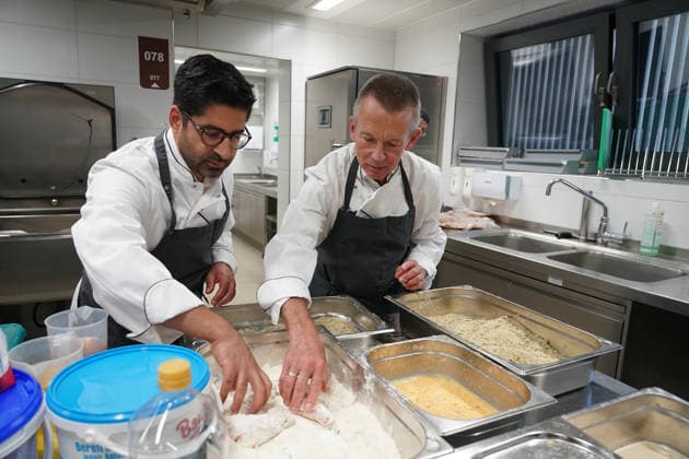 Hessens Wirtschaftsminister Kaweh Mansoori (SPD) und der Landrat des Kreis Groß-Gerau Thomas Will (SPD) bereiten in der Küche des AVM-Ausbildungsrestaurants Mangold in Bischofsheim ein Backhendl in Kürbiskern-Panade zu mit Küchenchef Florian Rothbauer - Bischofsheim 28.07.2026: Wirtschaftsminister Kaweh Mansoori besucht das Mangold *** Hesse’s Minister of Economic Affairs, Kaweh Mansoori (SPD), and Thomas Will (SPD), District Administrator of Groß Gerau, are preparing a fried chicken in a pumpkin seed breading in the kitchen of the AVM training restaurant Mangold in Bischofsheim with Head Chef Florian Rothbauer. Bischofsheim, July 28, 2026 2026 Minister of Economic Affairs Kaweh Mansoori visits the Mangold