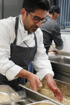 Hessens Wirtschaftsminister Kaweh Mansoori (SPD) und der Landrat des Kreis Groß-Gerau Thomas Will (SPD) bereiten in der Küche des AVM-Ausbildungsrestaurants Mangold in Bischofsheim ein Backhendl in Kürbiskern-Panade zu mit Küchenchef Florian Rothbauer - Bischofsheim 28.07.2026: Wirtschaftsminister Kaweh Mansoori besucht das Mangold *** Hesse’s Minister of Economic Affairs, Kaweh Mansoori (SPD), and Thomas Will (SPD), District Administrator of Groß Gerau, are preparing a fried chicken in a pumpkin seed breading in the kitchen of the AVM training restaurant Mangold in Bischofsheim with Head Chef Florian Rothbauer. Bischofsheim, July 28, 2026 2026 Minister of Economic Affairs Kaweh Mansoori visits the Mangold