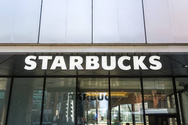 Am Morgen spiegelt sich das Glas von Starbucks Ladenfront in Toronto wider. Auffälliges weißes Logo auf schwarzem Baldachin, Glasfassade, die Bürotürme und vorbeifahrende Gebäude widerspiegelt Starbucks storefront Toronto glass reflections morning. Bold White Logo on Black Canopy, Glass Facade Mirroring Office Towers and Passing Copyright: imageBROKER NadtochiyxPhotograph ibliqx18495730.jpg