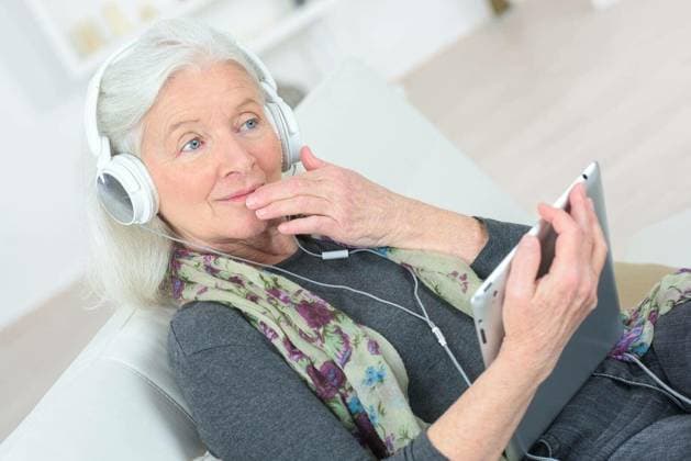 Senior lady listening to music through headphones model released Symbolfoto Copyright: xphovoirx Panthermedia74163308.jpg