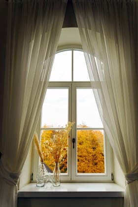 Sheer curtains frame an arched window autumn view Burbi?kis, Utena County, Lithuania CR_EDSAHG260728B-2089476-01 ,model released, Symbolfoto ,property released