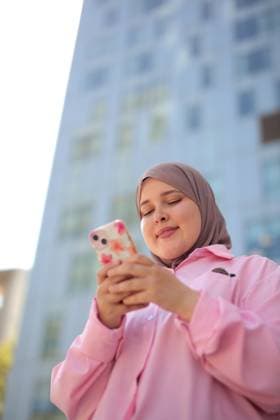 Young Muslim woman smiles while using her phone Barcelona, Catalonia, Spain CR_MIPI260728-2088681-01 ,model released, Symbolfoto ,property released