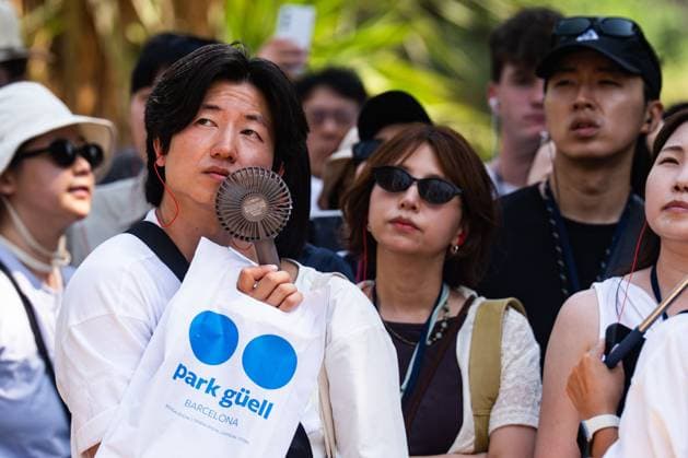 July 29, 2026, Barcelona, ES: BARCELONA, SPAIN - JULY 29, 2026. Asian tourists shield themselves from the sun with hand fans and portable fans during a guided tour around the Sagrada FamoÂ­lia on the first day of the summer s fourth heatwave in Spain. Local authorities have issued high-temperature alerts across Catalonia, urging residents and visitors to take precautions against extreme heat expected to last throughout the week. Barcelona ES  - ZUMAq101 20260729_zna_q101_096 Copyright: xMarcxAsensioxClupesx