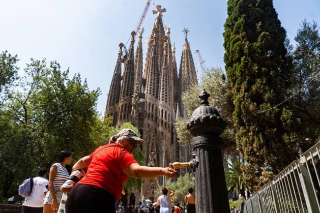 July 29, 2026, Barcelona, Spain: BARCELONA, SPAIN - JULY 29, 2026. A woman cools off in a fountain near the Sagrada Familia on the first day of the summer s fourth heatwave in Spain. Local authorities have issued high-temperature alerts across Catalonia, urging residents and visitors to take precautions against extreme heat expected to last throughout the week. Barcelona Spain  - ZUMAq101 20260729_zna_q101_103 Copyright: xMarcxAsensioxClupesx