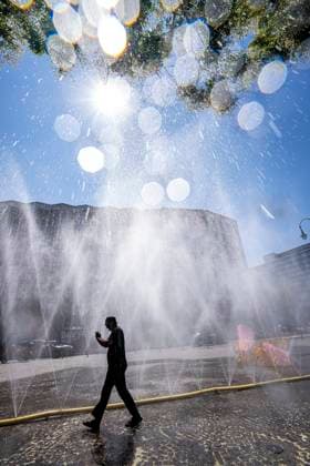 Cooling Cologne, Aktion der Stadt Köln zur Abkühlung von Hitzebelasteten Plätzen, hier der Rudolfplatz in der Innenstadt, bei knapp 37Â°C an dem Tag, ein Sprühschlauch verspritzt feine Wassertröpfen, die die unmittelbare Umgebung einige Grade abkühlt, eine Aktion die bei extremer Hitzebelastung vorgenommen wird, zur Anpassung des Stadtklimas an den Klimawandel, Passanten genießen den kühlenden Moment, dazu gibts Tipps zum Umgang mit Extremhitze, NRW, Deutschland, Extremhitze *** Cooling Cologne, a City of Cologne initiative to cool down areas affected by heat, here at Rudolfplatz in the city center, with temperatures nearing 37°C that day, a spray hose disperses fine droplets of water that cool the immediate surroundings by a few de