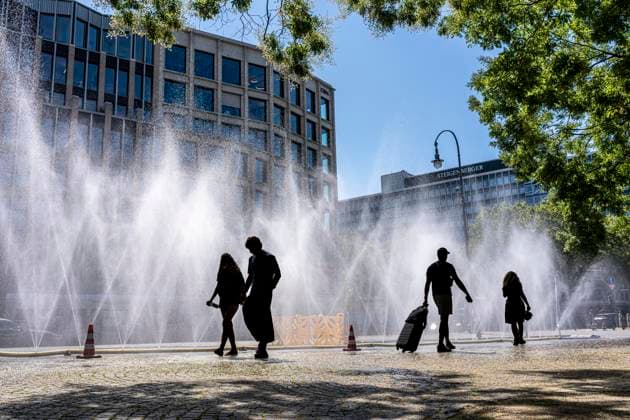 Cooling Cologne, Aktion der Stadt Köln zur Abkühlung von Hitzebelasteten Plätzen, hier der Rudolfplatz in der Innenstadt, bei knapp 37Â°C an dem Tag, ein Sprühschlauch verspritzt feine Wassertröpfen, die die unmittelbare Umgebung einige Grade abkühlt, eine Aktion die bei extremer Hitzebelastung vorgenommen wird, zur Anpassung des Stadtklimas an den Klimawandel, Passanten genießen den kühlenden Moment, dazu gibts Tipps zum Umgang mit Extremhitze, NRW, Deutschland, Extremhitze *** Cooling Cologne, a City of Cologne initiative to cool down areas affected by heat, here at Rudolfplatz in the city center, with temperatures nearing 37°C that day, a spray hose disperses fine droplets of water that cool the immediate surroundings by a few de