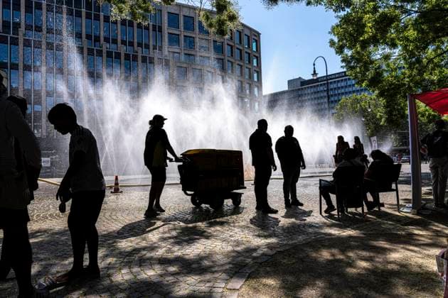 Cooling Cologne, Aktion der Stadt Köln zur Abkühlung von Hitzebelasteten Plätzen, hier der Rudolfplatz in der Innenstadt, bei knapp 37Â°C an dem Tag, ein Sprühschlauch verspritzt feine Wassertröpfen, die die unmittelbare Umgebung einige Grade abkühlt, eine Aktion die bei extremer Hitzebelastung vorgenommen wird, zur Anpassung des Stadtklimas an den Klimawandel, Passanten genießen den kühlenden Moment, dazu gibts Tipps zum Umgang mit Extremhitze, NRW, Deutschland, Extremhitze *** Cooling Cologne, a City of Cologne initiative to cool down areas affected by heat, here at Rudolfplatz in the city center, with temperatures nearing 37°C that day, a spray hose disperses fine droplets of water that cool the immediate surroundings by a few de