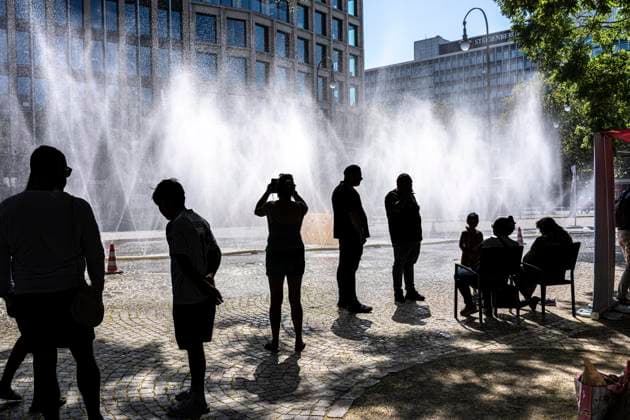 Cooling Cologne, Aktion der Stadt Köln zur Abkühlung von Hitzebelasteten Plätzen, hier der Rudolfplatz in der Innenstadt, bei knapp 37Â°C an dem Tag, ein Sprühschlauch verspritzt feine Wassertröpfen, die die unmittelbare Umgebung einige Grade abkühlt, eine Aktion die bei extremer Hitzebelastung vorgenommen wird, zur Anpassung des Stadtklimas an den Klimawandel, Passanten genießen den kühlenden Moment, dazu gibts Tipps zum Umgang mit Extremhitze, NRW, Deutschland, Extremhitze *** Cooling Cologne, a City of Cologne initiative to cool down areas affected by heat, here at Rudolfplatz in the city center, with temperatures nearing 37°C that day, a spray hose disperses fine droplets of water that cool the immediate surroundings by a few de
