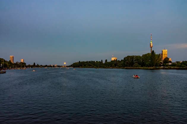 oxbow lake Alte Donau (Old Danube), full moon rise, high-rises at Donaucity, tower Donauturm, boats Vienna 22. Donaustadt Wien Austria