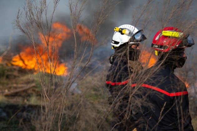 Wildfire Near Le Temple - Gironde Two firefighters observe advancing flames during wildfire suppression operations near Le Temple, Gironde, southwestern France, on July 29, 2026. Intense flames burn through dry vegetation as crews assess fire behavior and continue efforts to contain the wildfire.  Copyright: xSaptexFabrice ABACAx