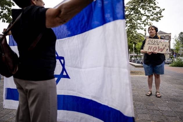 ROTTERDAM - A woman with an Israeli flag and a pro-Palestinian activist precede the commemoration of the deportation of Jewish Rotterdammers during the Second World War. In Rotterdam, deportations began in 1942 from Warehouse 24 in the port area. The occupiers used that location as a gathering place where Dutch Jews were brought together. ROBIN VAN LONKHUIJSEN ANP netherlands out - belgium out  Copyright: xx x564582690x originalFilename: 564582690.jpg