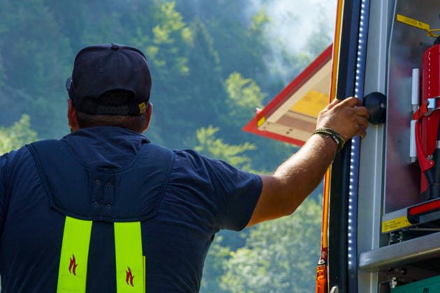 Firefighters battle mountain wildfire near Oberwössen in Bavaria. Germany - Oberwössen, 30.07.2026 One of the firefighters watch the helicopters flying towards the mountain as firefighters battle a mountain wildfire above Oberwössen in the Traunstein district of Bavaria on Thursday. Ground crews, supported by police helicopters carrying out bambi buckets, work to contain the blaze in steep and difficult-to-access terrain. Bavaria