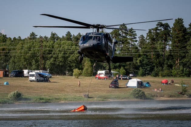 Forest fire breaks out in Czech Republic VETRKOVICE, CZECH REPUBLIC - JULY 30: A black hawk helicopter collects water for extinguishing fires in a bambi bag above the water surface in Vetrkovice (Moravian-Silesian Region), Czech Republic on July 30, 2026. The fire is being extinguished by 30 units of firefighters, which is approximately 150 firefighters, according to the press spokesperson of the fire department. Also two Black Hawk helicopters and a police Bell. The area affected by the fire is approximately 27 hectares. Lukas Kabon Anadolu Vetrkovice Czech Republic. Editorial use only. Please get in touch for any other usage.  Copyright: x2026xAnadoluxLukasxKabonx