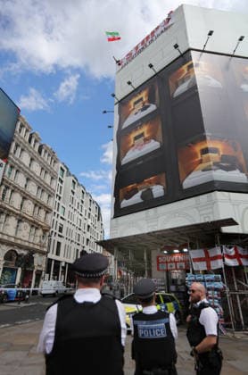 Rooftop Protest By Iranian Monarchists in London - 30 Jul 2026 Two protesters get onto the roof and stage a roof top occupation, waving the old Shahist Iranian flag and unfurling a banner saying ’Stop Executions in Iran’ watched by police officers at ground level during the occupation. Iranian Monarchists, supporters of the Shah dropped a banner from the roof of the Trocadero Centre in London’s Piccadilly Circus. They are protesting against the executions in Iran. They say thousands have been killed by the current Islamic regime. London United Kingdom Copyright: xMartinxPopex xSOPAxImagesx MPOPE_A734013