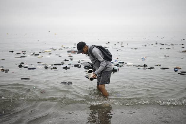 Ceuta wakes up to a steady stream of people from Morocco and thousands of young people wandering the streets. A man picks up a pair of flip-flops from the water, on July 31, 2026, in Ceuta, Spain. The autonomous city of Ceuta awoke to a steady stream of people continuing to enter from Morocco early this morning, following a night in which the influx through the border area never ceased. Thousands of migrants have entered the autonomous city today by swimming and also on on foot along the breakwater that separates the autonomous city from Morocco. Police sources indicate that more than 20,000 people have entered Spain. JULY 31, 2026. Jesú, Ceuta, Ceuta, Spain  Copyright: xJesusxTorresx 7697092