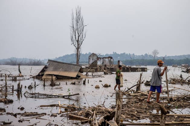 July 31, 2026, Lebak Regency, Banten, Indonesia: People carry fishing net as they walk through the ruins of Somang village, which has re-emerged as water levels recede during the dry season, amid forecasts that El NioÂ±o may contribute to drier-than-normal conditions, at Karian Reservoir in Sajira district, Lebak Regency, Banten province, Indonesia, July 31, 2026. Lebak Regency Indonesia  - ZUMAp283 20260731_zip_p283_016 Copyright: xClaudioxPramanax