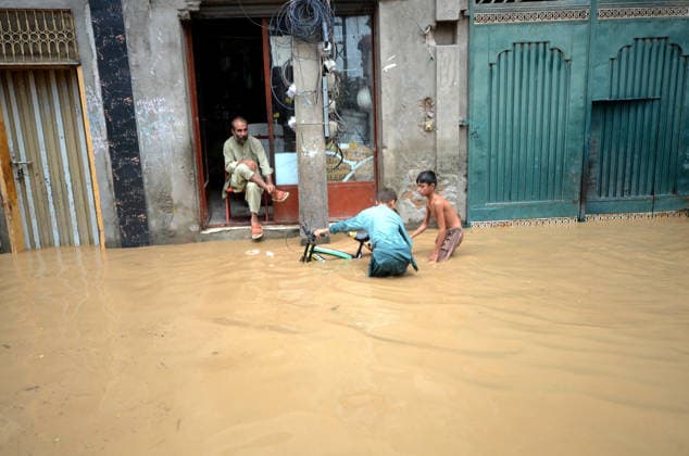 July 31, 2026, Peshawar, Peshawar, Pakistan: Residents wade through flooded street as monsoon rains inundate Peshawar..People wade through a flooded street during heavy monsoon rain in Peshawar, Khyber Pakhtunkhwa province, Pakistan, on July 31, 2026. Pakistan s Meteorological Department (PMD) forecast the current monsoon spell to continue until August 5, warning of widespread rain, thunderstorms, heavy to very heavy downpours, and the risk of urban flooding, flash floods, landslides and river flooding across parts of the country. Peshawar Pakistan - ZUMAa217 20260731_znp_a217_020 Copyright: xHussainxAlix