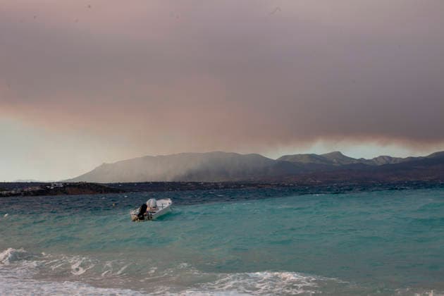 Wildfire Smoke and Strong Winds Hit Corinthia Coast A boat rests on the shore as waves break along the coast beneath a sky filled with wildfire smoke in Almiri, Corinthia, Greece on August 1, 2026. Strong winds generate rough sea conditions and carry smoke across the Saronic Gulf from a wildfire burning in the neighboring regional unit of Viotia, where firefighters continue efforts to contain the blaze. Almiri Corinthia Greece Copyright: xElvisxTakahashixMantellox