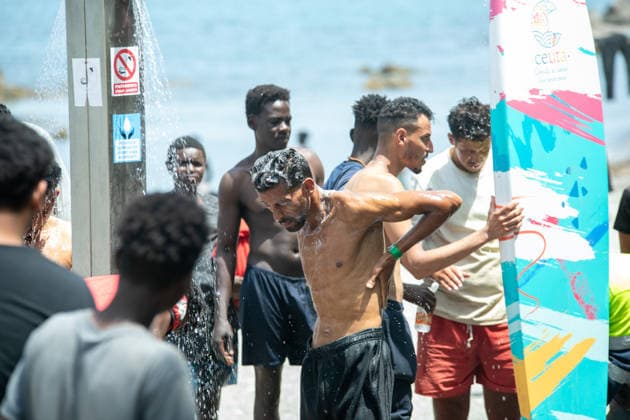 August 1, 2026, Ceuta, Ceuta, Spain: A group of migrants use beach showers near the Temporary Stay Centre for Immigrants Ceuta Spain - ZUMAd308 20260801_zsp_d308_080 Copyright: xJuanxCarlosxLucasx
