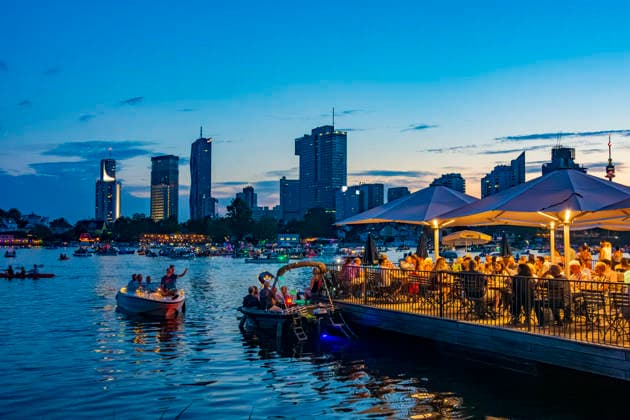 Lichterlfest (Lichterfest, Festival of Lights) at oxbow lake Alte Donau (Old Danube), illuminated boats, high-rises of Donaucity, floating restaurant Strandcafe Vienna 22. Donaustadt Wien Austria