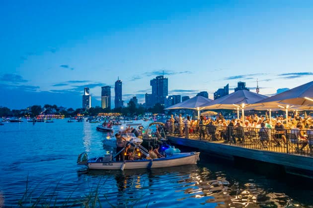 Lichterlfest (Lichterfest, Festival of Lights) at oxbow lake Alte Donau (Old Danube), illuminated boats, high-rises of Donaucity, floating restaurant Strandcafe Vienna 22. Donaustadt Wien Austria