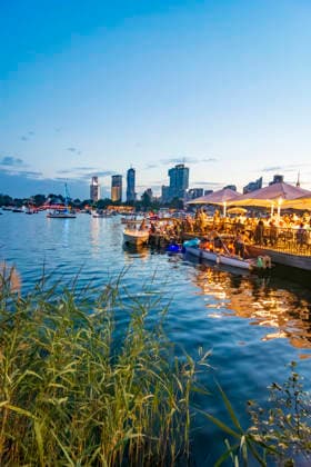 Lichterlfest (Lichterfest, Festival of Lights) at oxbow lake Alte Donau (Old Danube), illuminated boats, high-rises of Donaucity, floating restaurant Strandcafe Vienna 22. Donaustadt Wien Austria