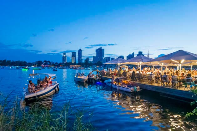 Lichterlfest (Lichterfest, Festival of Lights) at oxbow lake Alte Donau (Old Danube), illuminated boats, high-rises of Donaucity, floating restaurant Strandcafe Vienna 22. Donaustadt Wien Austria