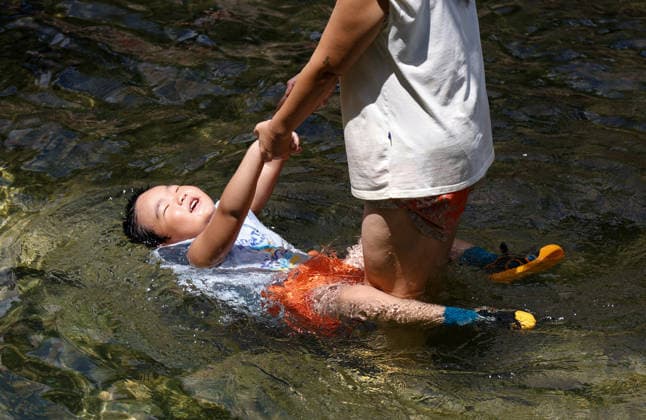 (260802) -- SEOUL, Aug. 2, 2026 -- A child plays at the Cheonggye stream to cool off amid a heatwave in Seoul, South Korea, Aug. 2, 2026. (Photo by Xinhua) SOUTH KOREA-HEATWAVE-COOLING OFF JunxHyosang 