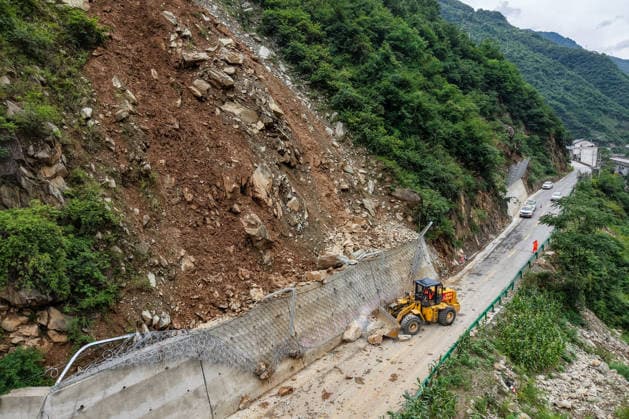 News Bilder des Tages (260802) -- LONGNAN, Aug. 2, 2026 -- A drone photo taken on Aug. 2, 2026 shows staff members clearing a road blocked by a landslide in Caoping Village of Fengxiang Township in Longnan, northwest China s Gansu Province. Longnan in northwest China s Gansu Province has activated Level II emergency response for flood control due to widespread heavy rainfall since Wednesday. Authorities at different levels have carried out inspections and assessments for potential hazards and repairs of damaged infrastructure, so as to safeguard people s lives and property. ) CHINA-GANSU-LONGNAN-FLOOD-PREVENTION WORK (CN) LangxBingbing 