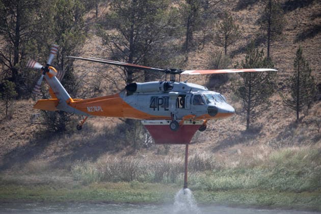 August 2, 2026, Prineville, Or, United States: A Sikorsky UH-60L Black Hawk wildland firefighting helicopter lifts off after refilling the belly tank from Joe Fisher Reservoir during operations fighting the Brewer Fire, July 27, 2026, near Prineville, Oregon. The heavy lift helicopter can transport 15 firefighters or deliver 1,000 gallons of water per drop directly to active fire-lines. Prineville United States - ZUMAp138 20260802_zaa_p138_011 Copyright: xAndrewxAvitt UsxForestx