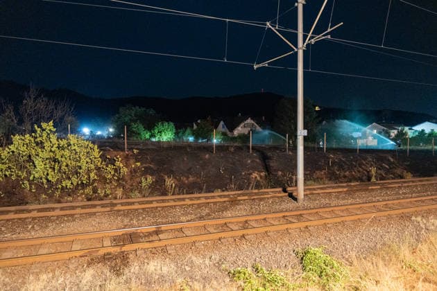 Großer Flächenbrand bedroht Wohngebiet Am 03.08.2026 gegen 02:00 Uhr brannten zwischen Seeheim-Jugenheim und Alsbach im Landkreis Darmstadt-Dieburg rund 28.000 Quadratmeter Feld und Gestrüpp entlang der L3100. Die Feuerwehr stoppte die Flammen etwa fünf Meter vor angrenzenden Wohnhäusern. Ein Anwohner erlitt beim eigenständigen Löschversuch eine Rauchgasvergiftung und wurde vom Rettungsdienst in ein Krankenhaus gebracht. Die Straßenbahnstrecke zwischen Alsbach und Seeheim-Jugenheim wurde gesperrt, ein Schienenersatzverkehr eingerichtet. Zur Brandbekämpfung kam eine Drohne mit Wärmebildkamera zum Aufspüren von Glutnestern zum Einsatz. Seeheim-Jugenheim Hessen Deutschland *** Large Wildfire Threatens Residential Area On August 3,