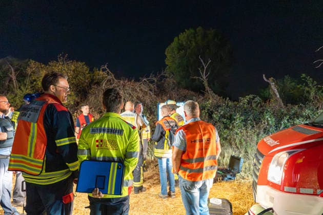 Großer Flächenbrand bedroht Wohngebiet Am 03.08.2026 gegen 02:00 Uhr brannten zwischen Seeheim-Jugenheim und Alsbach im Landkreis Darmstadt-Dieburg rund 28.000 Quadratmeter Feld und Gestrüpp entlang der L3100. Die Feuerwehr stoppte die Flammen etwa fünf Meter vor angrenzenden Wohnhäusern. Ein Anwohner erlitt beim eigenständigen Löschversuch eine Rauchgasvergiftung und wurde vom Rettungsdienst in ein Krankenhaus gebracht. Die Straßenbahnstrecke zwischen Alsbach und Seeheim-Jugenheim wurde gesperrt, ein Schienenersatzverkehr eingerichtet. Zur Brandbekämpfung kam eine Drohne mit Wärmebildkamera zum Aufspüren von Glutnestern zum Einsatz. Seeheim-Jugenheim Hessen Deutschland *** Large Wildfire Threatens Residential Area On August 3,