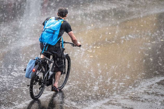 Starkregen in Göttingen 03.08.2026, Göttingen --- Eine Radfahrerin fährt während eines Starkregens durch eine Straße in Göttingen.. Göttingen Niedersachsen Deutschland *** Heavy Rain in Göttingen, August 3, 2026; Göttingen: A cyclist rides down a street in Göttingen during a heavy rainstorm. Göttingen, Lower Saxony, Germany