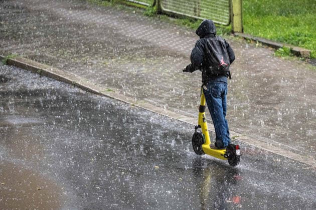 Starkregen in Göttingen 03.08.2026, Göttingen --- Ein Mann fährt während eines Starkregens mit einem E-Scooter durch Göttingen. Göttingen Niedersachsen Deutschland *** Heavy Rain in Göttingen, August 3, 2026, Göttingen: A man rides an e-scooter through Göttingen during a heavy rainstorm. Göttingen, Lower Saxony, Germany