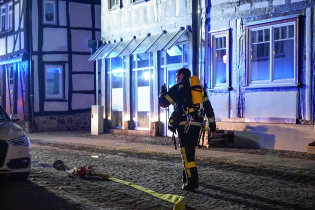 Feuer im Dachgeschoss eines Fachwerkhauses Flammen schlagen aus dem Fenster Feuerwehr riegelt enge Altstadt ab Am 03.08.2026 brannte gegen 21:00 Uhr ein Fachwerkhaus in der Oberstadt 18 in der Altstadt von Lich. Der Brand betraf das Obergeschoss und den Dachbereich des Gebäudes, es kam zu starker Rauchentwicklung und Flammenaustritt. Beim Eintreffen der Feuerwehr befand sich niemand mehr im Gebäude. Die Freiwillige Feuerwehr Lich leitete Außen- und Innenangriff ein und baute wegen der engen Altstadtbebauung eine Riegelstellung mit der Drehleiter zum Schutz der Nachbarhäuser auf. Lich Hessen Deutschland *** Fire in the attic of a half-timbered house; flames are shooting out of the window; firefighters cordon off the narrow old t