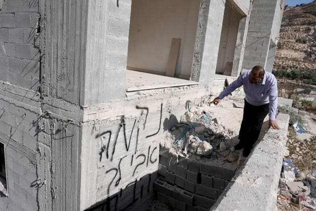 Israeli settlers set fire to three cars and damaged a power line in Nablus NABLUS, WEST BANK, PALESTINE - AUGUST 04: A man points to Hebrew writing on a building under construction as Palestinians inspect burnt-out cars following a raid by Israeli settlers who attacked homes, set three cars on fire, and damaged power lines between the villages of Jalud and Telfit near Nablus in West Bank, Palestine on August 04, 2026. Issam Rimawi Anadolu Nablus West Bank. Editorial use only. Please get in touch for any other usage.  Copyright: x2026xAnadoluxIssamxRimawix