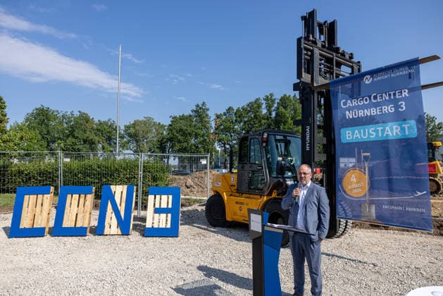 Baustart Cargo ‹Center 3 am Flughafen Nürnberg, Nürnberg, 04.08.2026 Ein Redner spricht am Podium anlässlich des Baustarts für das neue Cargo Center Nürnberg 3 (CCN 3) am Flughafen Nürnberg. Im Hintergrund stehen ein Gabelstapler sowie ein Werbebanner zur Baumaßnahme. Der Ausbau des Cargo-Bereichs reagiert auf die anhaltend hohe Nachfrage nach Logistikflächen. Nürnberg Flughafen Bayern Deutschland *** Groundbreaking for Cargo Center 3 at Nuremberg Airport, Nuremberg, August 4, 2026 A speaker addresses the audience from the podium at the groundbreaking ceremony for the new Nuremberg Cargo Center 3 (CCN 3) at Nuremberg Airport. In the background are a forklift and a promotional banner for the construction project. The expansion of 20260804-286A4179-M4000