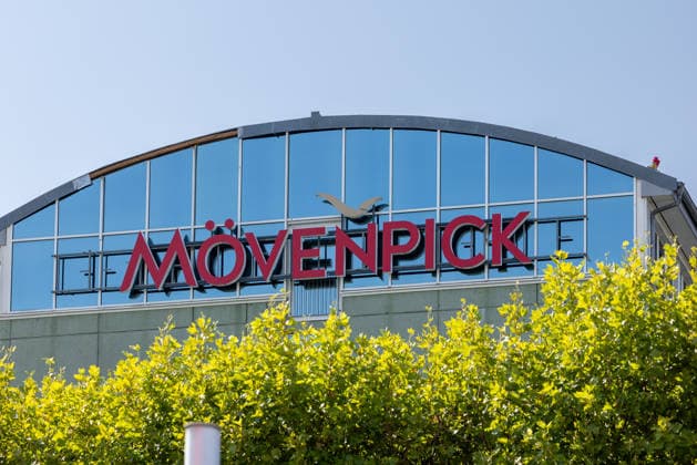 Flughafen Nürnberg, 04.08.2026 Gebäude eines Mövenpick Hotels mit markantem Logo direkt gegenüber dem Flughafenterminal. Die geschwungene Glasfassade spiegelt den blauen Himmel wider. Nürnberg Flughafen Bayern Deutschland *** Nuremberg Airport, August 4, 2026 A Mövenpick Hotel building with a distinctive logo directly across from the airport terminal The curved glass facade reflects the blue sky Nuremberg Airport, Bavaria, Germany 20260804-1V9A6688-M4000