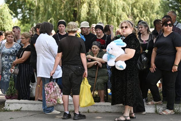 People pay their last respects to members of the Voronov family, killed when a Russian Iskander-M ballistic missile directly struck their home on the night of Thursday, July 30, Radushne settlement, Kryvyi Rih district, Dnipropetrovsk region, Ukraine, August 3, 2026. Five family members whose identities have been officially confirmed were laid to rest: parents Artem, 47, and Olena, 41, together with their children Mark, 17, Azarii Ilai, 11, and Emiliia, 6. Five other children who were in the house that night - Zakhar, Dominika, Viorika, Federika and one-and-a-half-year-old grandson Artem - are still officially listed as missing. Rescuers recovered 17 body fragments from the rubble, and complex forensic DNA examinations are under way to iden  Copyright: xDmytroxSmolienkox
