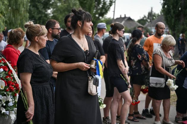 People pay their last respects to members of the Voronov family, killed when a Russian Iskander-M ballistic missile directly struck their home on the night of Thursday, July 30, Radushne settlement, Kryvyi Rih district, Dnipropetrovsk region, Ukraine, August 3, 2026. Five family members whose identities have been officially confirmed were laid to rest: parents Artem, 47, and Olena, 41, together with their children Mark, 17, Azarii Ilai, 11, and Emiliia, 6. Five other children who were in the house that night - Zakhar, Dominika, Viorika, Federika and one-and-a-half-year-old grandson Artem - are still officially listed as missing. Rescuers recovered 17 body fragments from the rubble, and complex forensic DNA examinations are under way to iden  Copyright: xDmytroxSmolienkox