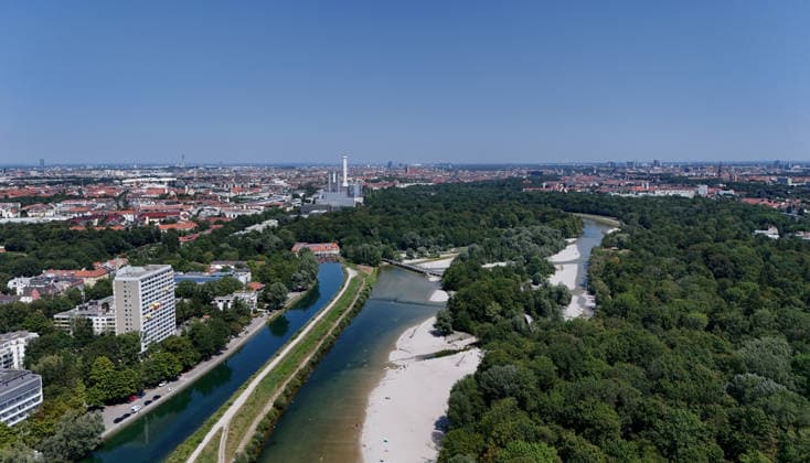 Ein Sommertag in der Landeshauptstadt München. Hier der Blick auf die auf die Isar und den Isar Werkskanal (li.) sowie den Flaucher, Badegelände, Kiesstrand, sowie die Skyline der Stadt München mit Blick Richtung Norden, Stadtblick, Häusermeer, Erholungsgebiet, Sonnen, baden, Abkühlen *** A summer day in Munich, the state capital. Here is a view of the Isar River and the Isar Werkskanal, as well as the Flaucher—a swimming area with a gravel beach—and the Munich skyline looking north: cityscape, sea of buildings, recreational area, sunbathing, swimming, cooling off