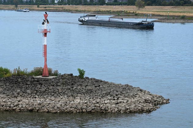 Historisches Niedrigwasser im Rhein, die Wasserschutzpolizei Duesseldorf meldet mit 23cm den niedrigsten in Duesseldorf gemessenen Rheinpegel, Tiefer Wasserstand, steiniges Flussufer, eine weit aufragende rote Ufermarkierung, im Hintergrund ein Frachtschiff, Duesseldorf, 04.08.2026 *** Historically low water levels on the Rhine; the Düsseldorf Water Police report that the Rhine’s water level in Düsseldorf has reached 23 cm—the lowest ever recorded there. Low water level, rocky riverbank, a tall red bank marker, and a cargo ship in the background, Düsseldorf, August 4, 2026
