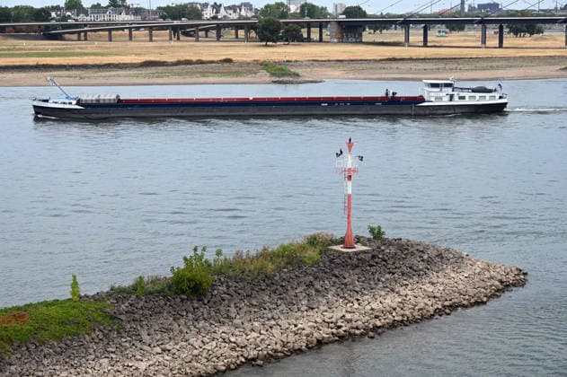 Historisches Niedrigwasser im Rhein, die Wasserschutzpolizei Duesseldorf meldet mit 23cm den niedrigsten in Duesseldorf gemessenen Rheinpegel, Tiefer Wasserstand, steiniges Flussufer, eine weit aufragende rote Ufermarkierung, im Hintergrund ein Frachtschiff, Duesseldorf, 04.08.2026 *** Historically low water levels on the Rhine; the Düsseldorf Water Police report that the Rhine’s water level in Düsseldorf has reached 23 cm—the lowest ever recorded there. Low water level, rocky riverbank, a tall red bank marker, and a cargo ship in the background, Düsseldorf, August 4, 2026