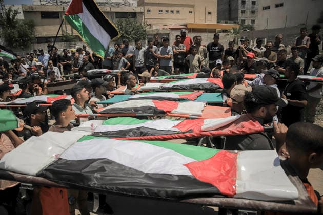 Gaza City Mass Funeral August 3 2026 Mourners carry bodies wrapped in Palestinian flags on stretchers during a mass funeral procession in the Al-Sabra neighborhood of Gaza City, Gaza Strip, on August 4, 2026. The remains of 112 members of the Abu Sharia and Al-Hasayneh families were recovered from the rubble of their home following an Israeli strike. Relatives stated the attack claimed the lives of more than 300 people. The bodies were buried at Al-Maamadani Cemetery as military operations continue across the territory. Gaza Gaza Strip Palestinian Territories Copyright: xMohammedxMxSkaikx