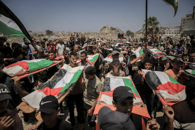 Gaza City Mass Funeral August 3 2026 Mourners carry bodies wrapped in Palestinian flags on stretchers during a mass funeral procession in the Al-Sabra neighborhood of Gaza City, Gaza Strip, on August 4, 2026. The remains of 112 members of the Abu Sharia and Al-Hasayneh families were recovered from the rubble of their home following an Israeli strike. Relatives stated the attack claimed the lives of more than 300 people. The bodies were buried at Al-Maamadani Cemetery as military operations continue across the territory. Gaza Gaza Strip Palestinian Territories Copyright: xMohammedxMxSkaikx